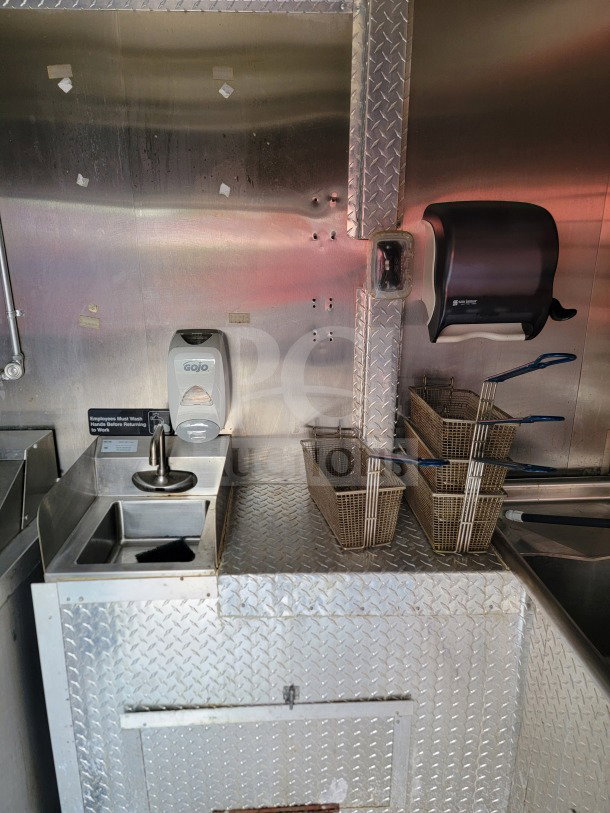 2021 Forest River 8.5' x 24' mobile kitchen trailer interior, featuring stainless steel surfaces, Royal Range cooking suite, and Arctic Air refrigeration. Visible hand wash station with Gojo soap dispenser and sanitation signage.