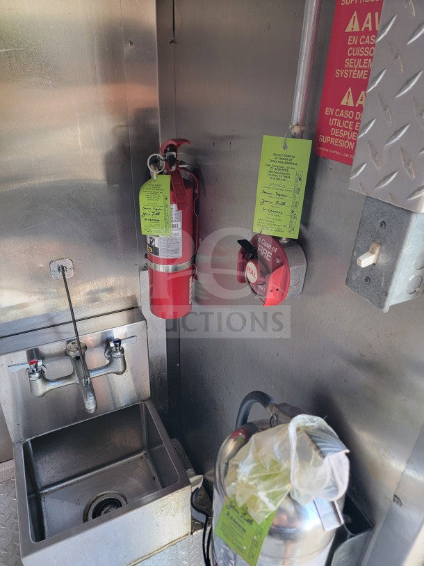 2021 Forest River 8.5' x 24' mobile kitchen trailer interior with a fire extinguisher, sink, and safety signage.