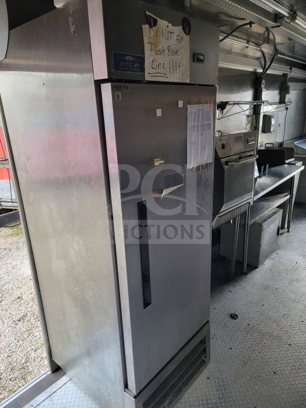 2021 Forest River mobile kitchen trailer interior featuring an Arctic Air commercial freezer. Note: "Do not fill past blue line" sign.