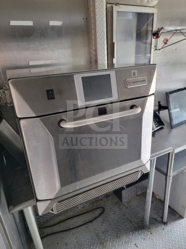 2021 Forest River 8.5' x 24' mobile kitchen trailer interior, featuring Merrychef unit, stainless steel surfaces, and shelving.