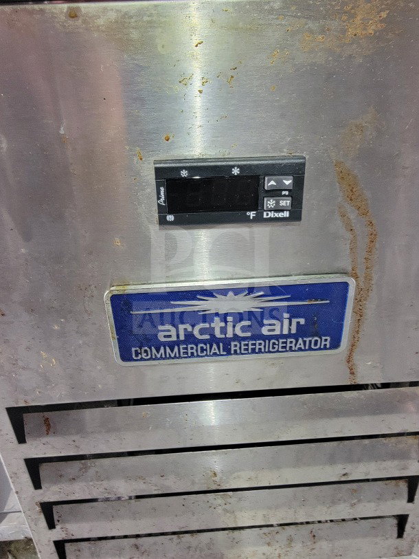 Arctic Air commercial refrigerator, stainless steel, model in used condition with visible wear and control panel.