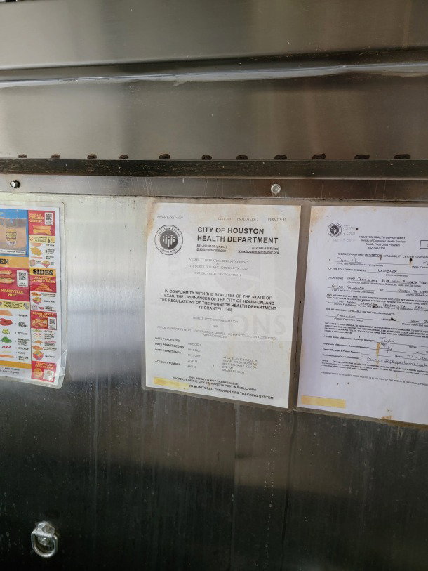 Health department certificates and notices displayed inside a Forest River mobile kitchen trailer, emphasizing compliance and inspection details.