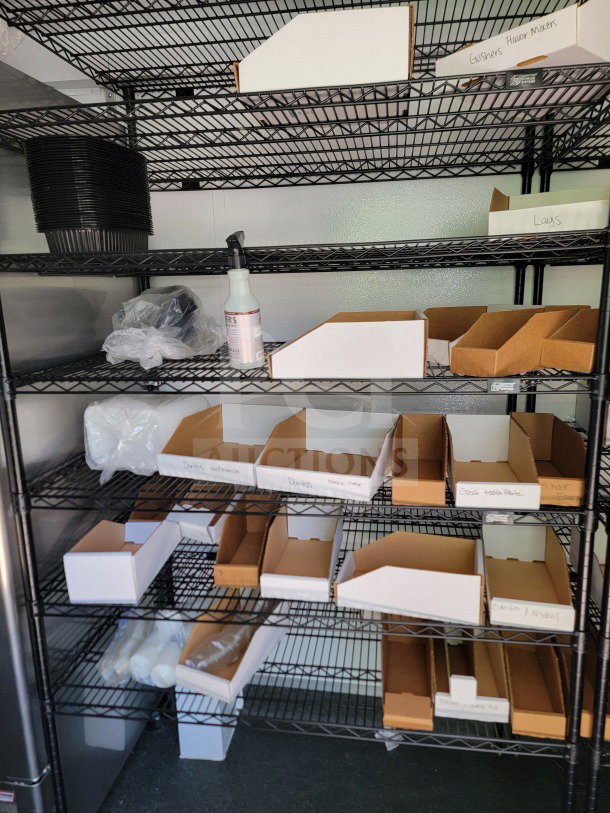 Interior shelving of 2021 SDG 8.5' x 26' trailer with organized storage boxes, plastic containers, and labeled sections.