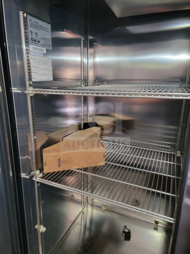 Interior view of a 2021 SDG 26' tandem-axle trailer with Turbo Air refrigeration. Metal shelving is visible.
