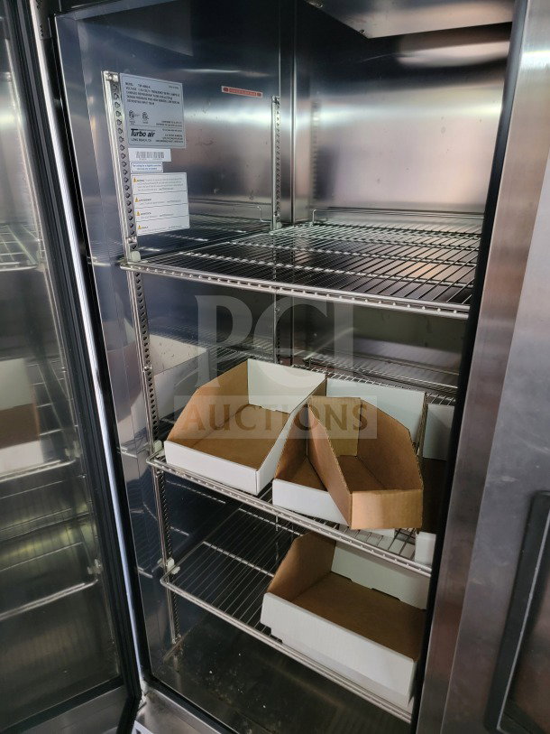 Interior view of 2021 SDG trailer with Turbo Air refrigeration, featuring metal shelving and cardboard boxes. Model 26.