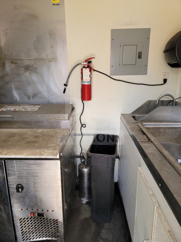Interior of 2019 Diamond Cargo 8.5' x 24' mobile kitchen trailer with fire extinguisher, sink, and utility panel.