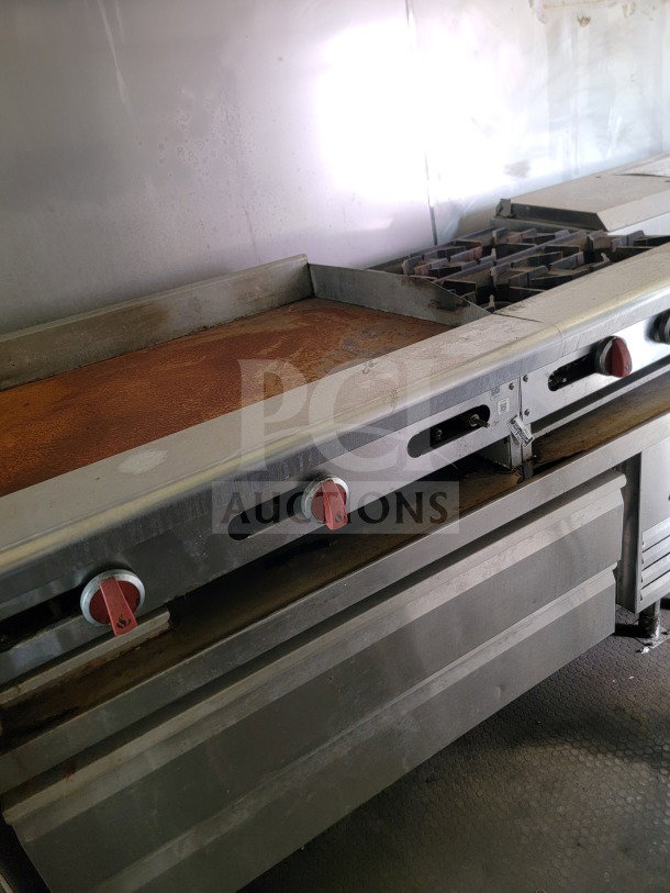 American Range cooking suite inside 2019 Diamond Cargo 8.5' x 24' mobile kitchen trailer, stainless steel with red knobs.