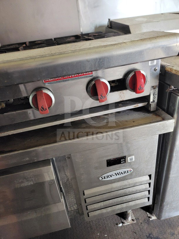 American Range cooking equipment with red knobs, integrated with Serv-Ware refrigeration in a commercial kitchen setup.