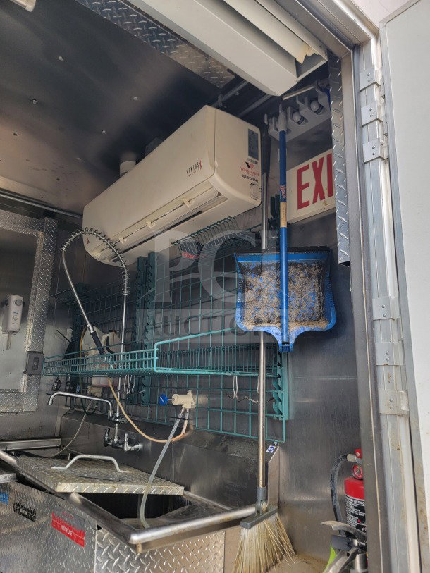 Mobile kitchen trailer interior showing stainless steel sink, storage, HVAC Mirage VentusX, and exit sign.
