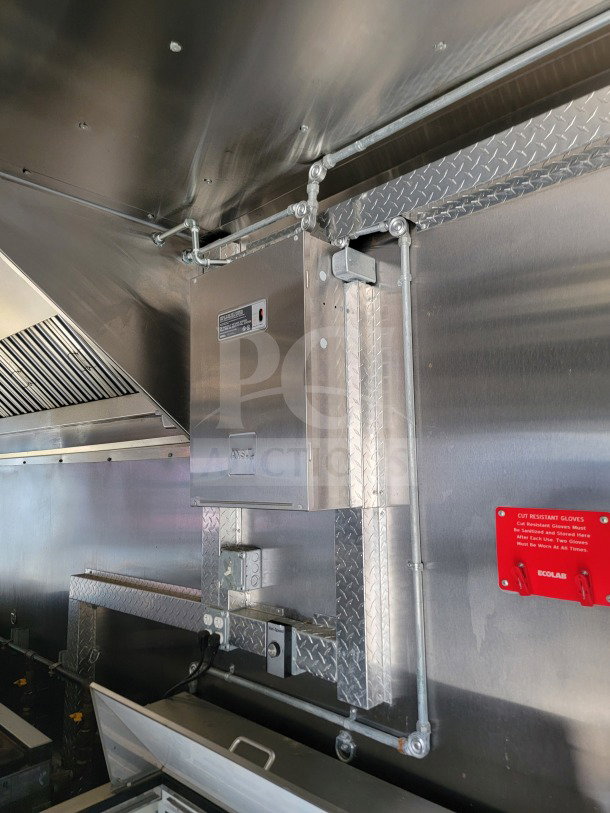 Interior view of a 2021 BT&S 8.5'x24' mobile kitchen trailer. Features stainless steel surfaces, Mirage VentusX HVAC, and safety instructions label.