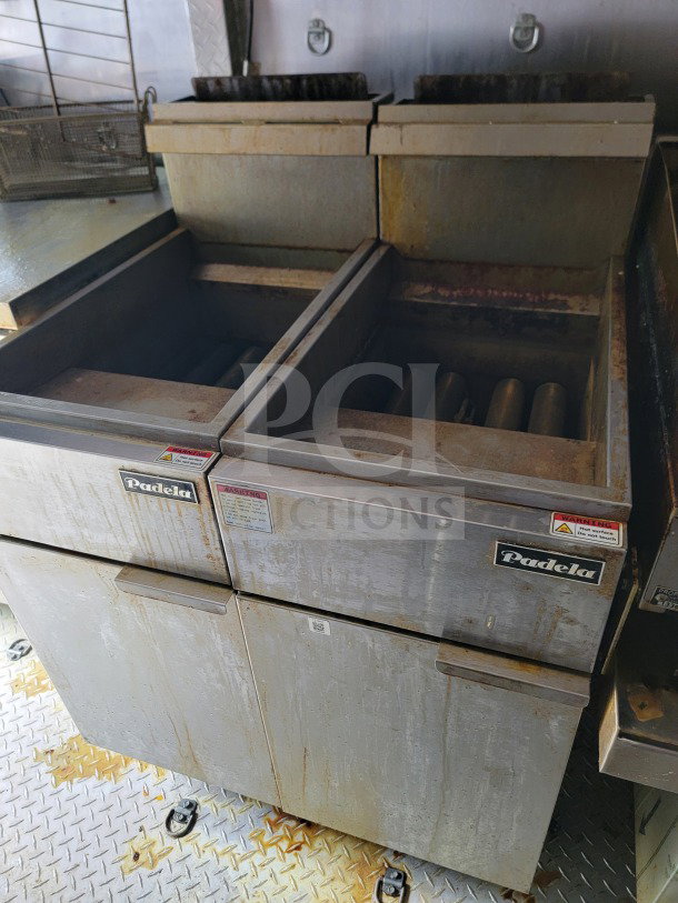 Padela commercial fryer unit inside BT&S mobile kitchen trailer. Visible wear and warning labels indicating operational hazards.