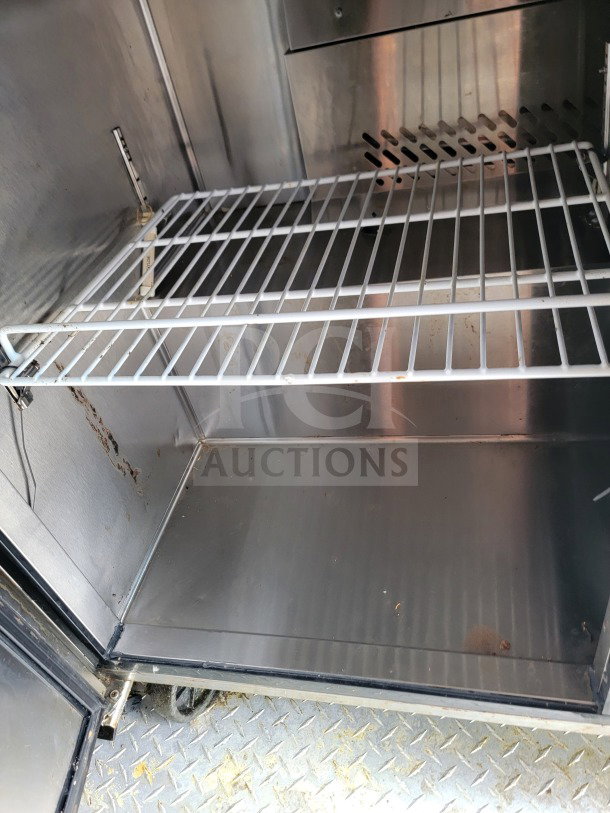Interior of a mobile kitchen trailer showing a metal shelving unit with slight wear. Part of LOT #15 BT&S Model 24.