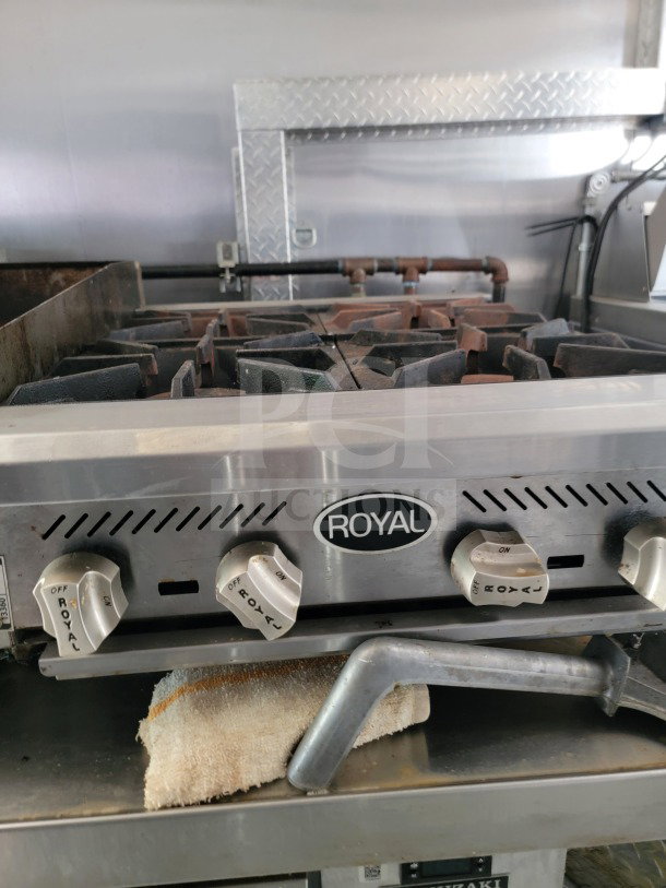 Royal stovetop in 2021 BT&S mobile kitchen trailer, features control knobs and a metal surface, used condition.
