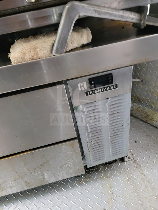 Hoshizaki refrigerator unit in a BT&S mobile kitchen trailer, showing model label and QR code on stainless steel panel.