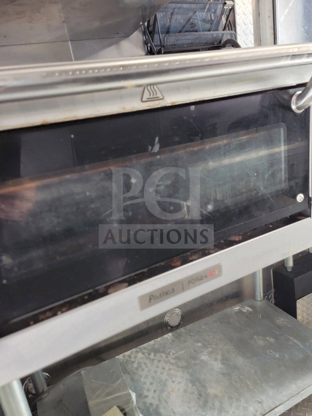Close-up of a kitchen appliance inside a 2021 BT&S mobile kitchen trailer, showing an oven unit with visible markings.