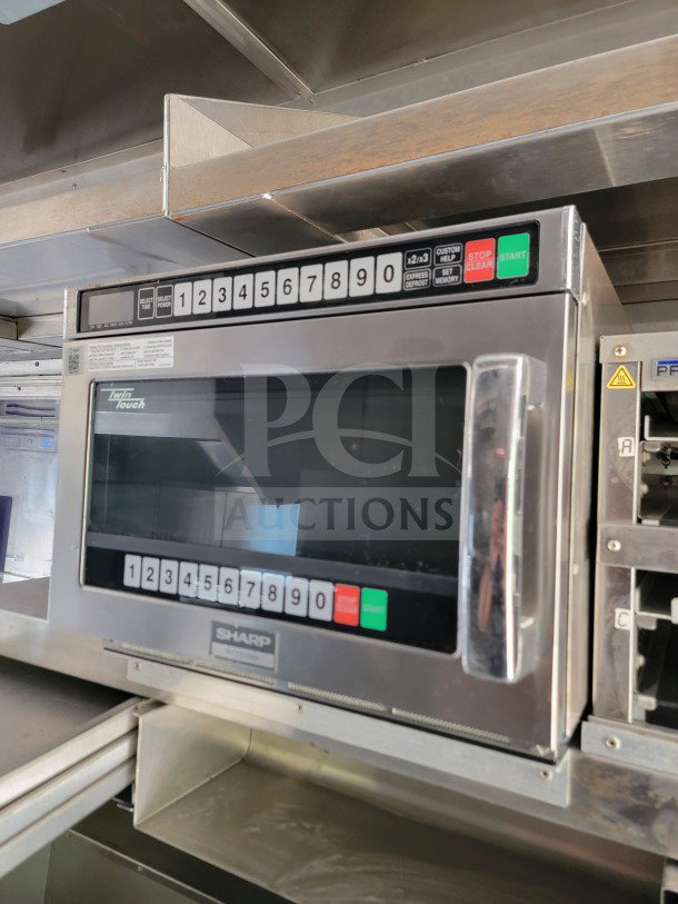 Sharp microwave with digital keypad, model Twin Touch, stainless steel finish, installed in mobile kitchen trailer.