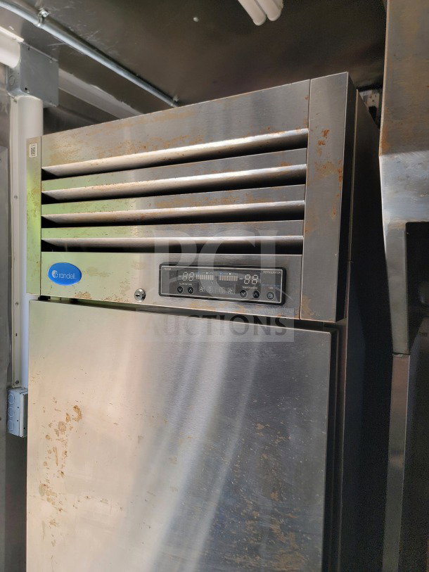 Randell stainless steel refrigerator unit in mobile kitchen trailer, shows exterior surface wear, digital control panel visible.