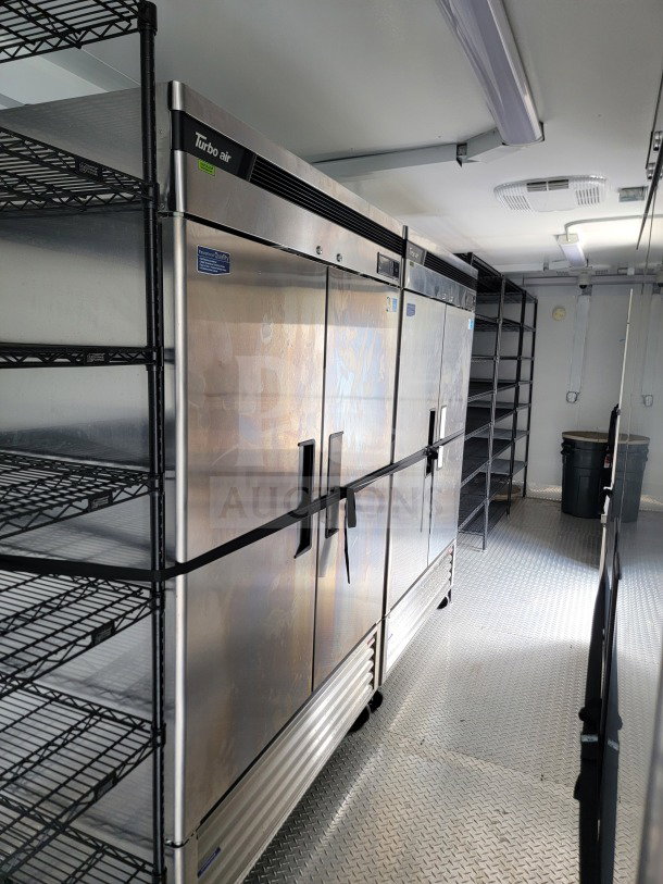 SDG 26 mobile kitchen trailer interior with Turbo Air fridge and shelving, showcasing spacious corporate configuration.