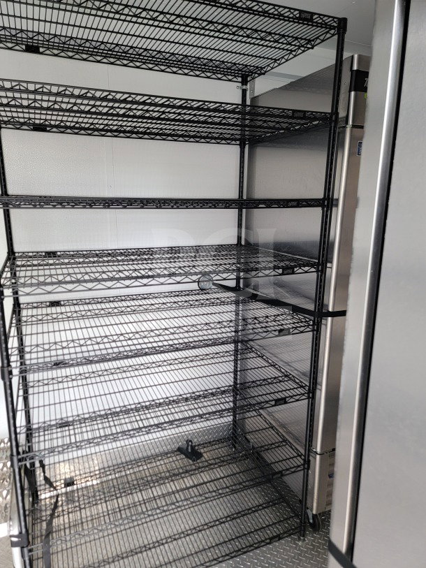 Black wire shelving inside a 2021 Southern Dimensions mobile kitchen trailer, showing ample storage space.