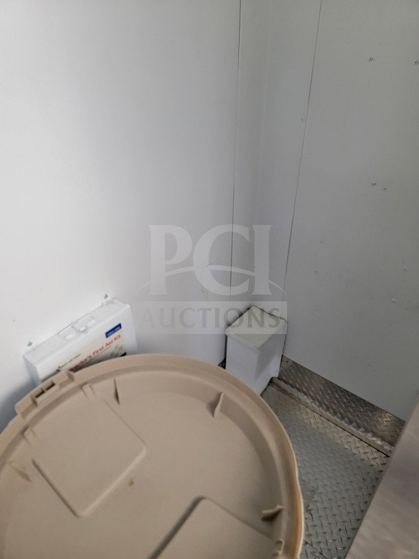 Interior view of LOT #17 2021 SDG 8.5' x 26' mobile kitchen trailer, showing part of the wall and a tan circular lid.