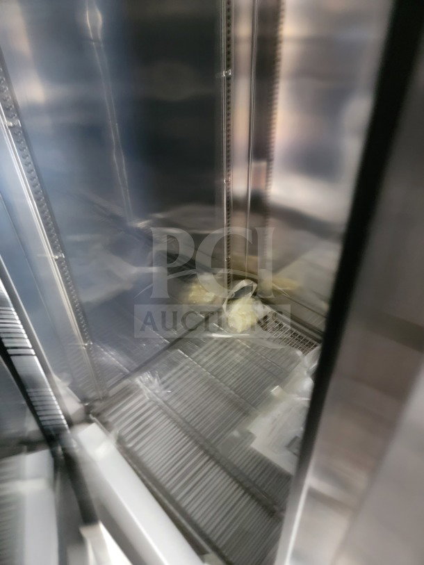 Interior view of the SDG Model 26 mobile kitchen trailer's refrigeration unit, showing metal shelving and plastic-wrapped items.