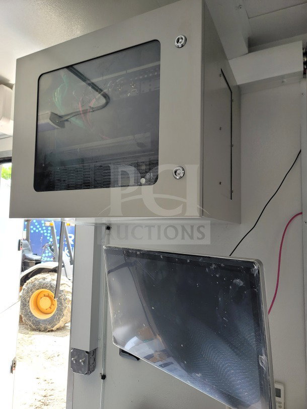 Internal view of Southern Dimensions mobile kitchen trailer showing electrical panel and monitor with wiring.