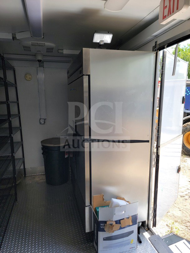 2021 SDG 8.5' x 26' mobile kitchen trailer interior, featuring Turbo Air/True refrigeration, shelves, and exit sign.