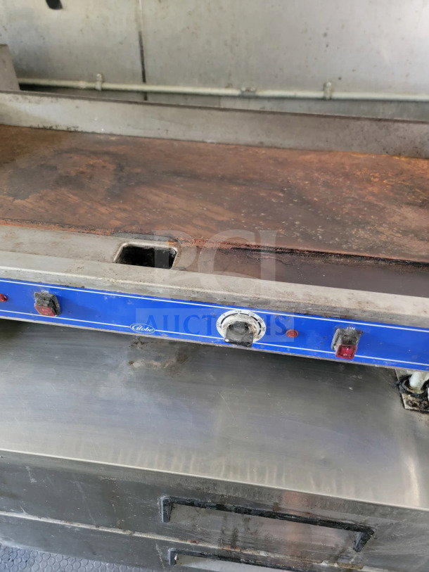 Globe Electric griddle with a blue control panel and temperature dial, part of a mobile kitchen trailer setup.