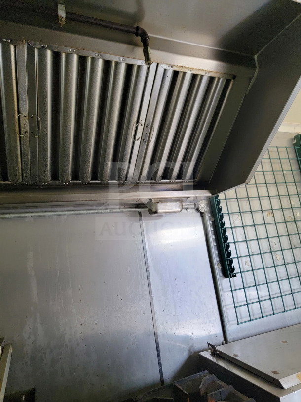 Interior view of Diamond Cargo 2019 mobile kitchen trailer. Features a stainless steel ventilation hood and shelving.