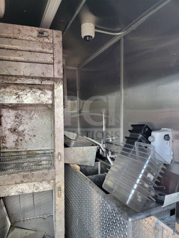 2021 Rock Solid Cargo 8.5' x 24' dual-axle mobile kitchen trailer interior, showing racks, sink, and storage areas.