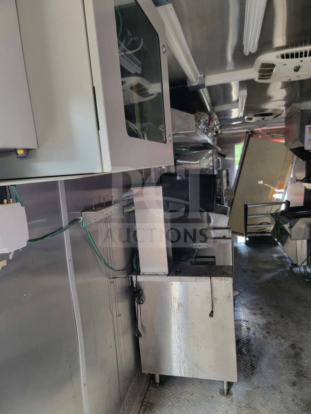 2021 Rock Solid Cargo 8.5' x 24' dual-axle mobile kitchen trailer interior, featuring stainless steel appliances and CaptiveAire hood system.