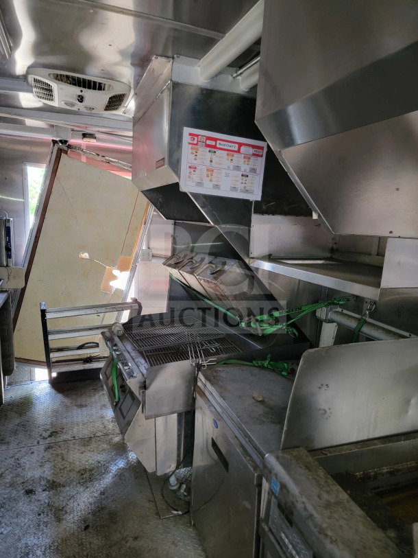 2021 Rock Solid Cargo 8.5' x 24' mobile kitchen trailer interior; features CaptiveAire hood, industrial grill, refrigeration units.