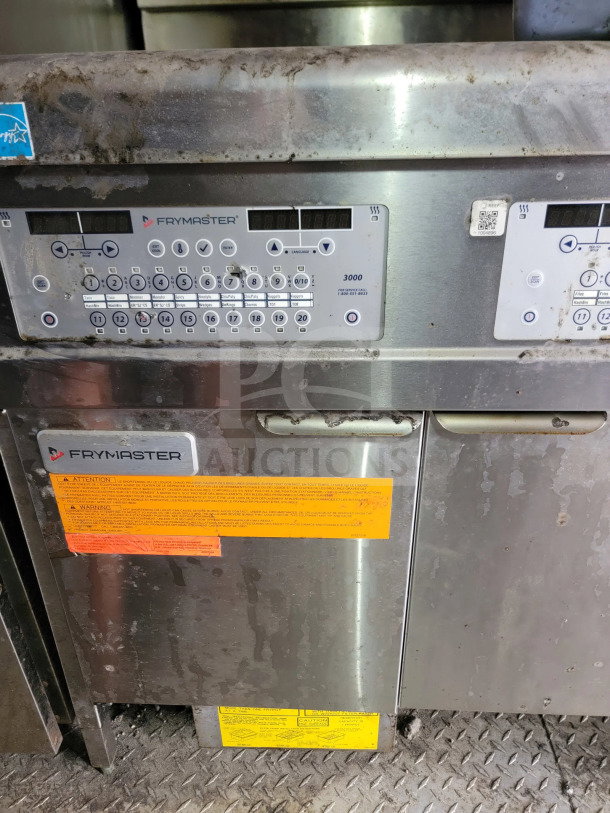 Frymaster equipment with digital controls inside 2021 Rock Solid Cargo mobile kitchen trailer. Visible warnings and labels.