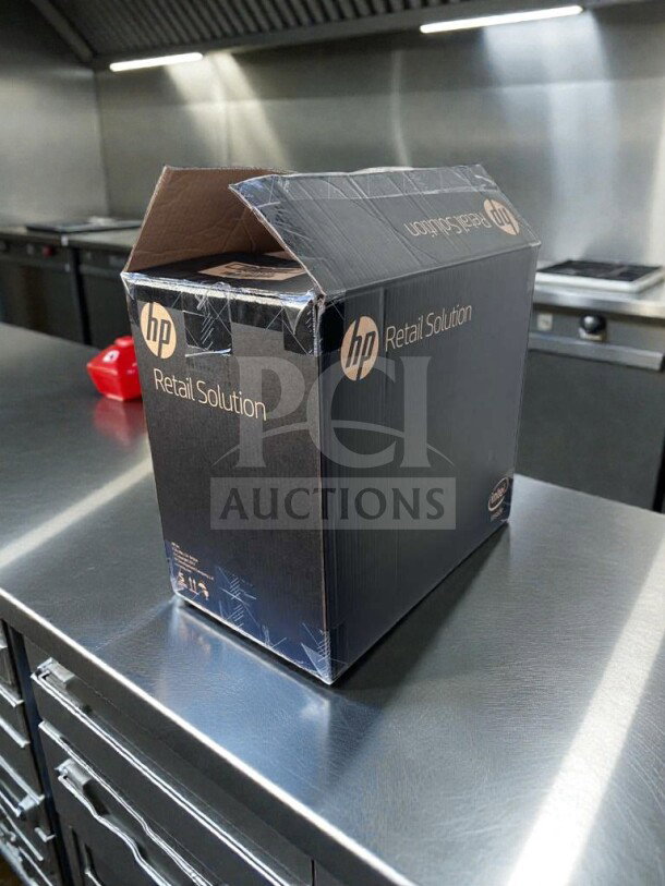 Brand new HP Engage One AIO Model 145 POS system in a sealed box, featuring commercial touchscreen and UL listed, on stainless steel surface.
