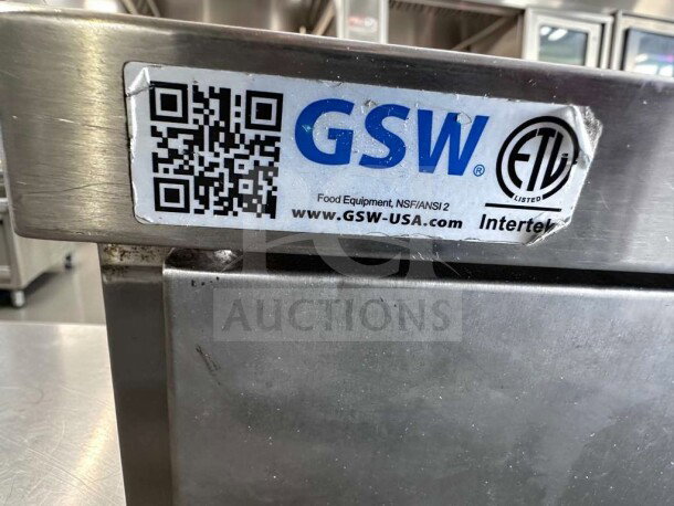 Stainless steel commercial work table by GSW USA, model CTD-P3048H, with hinged doors and mid-shelf. Tag shows NSF/ANSI 2 compliance and Intertek listing.