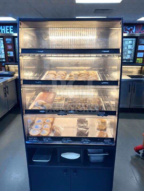 Immaculate condition, black illuminated dry display case with three levels for bakery items. Fully inspected and operational.