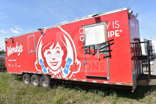 Wendy's food trailer, red exterior with branding, visible damage on door, triple axle. Used condition.