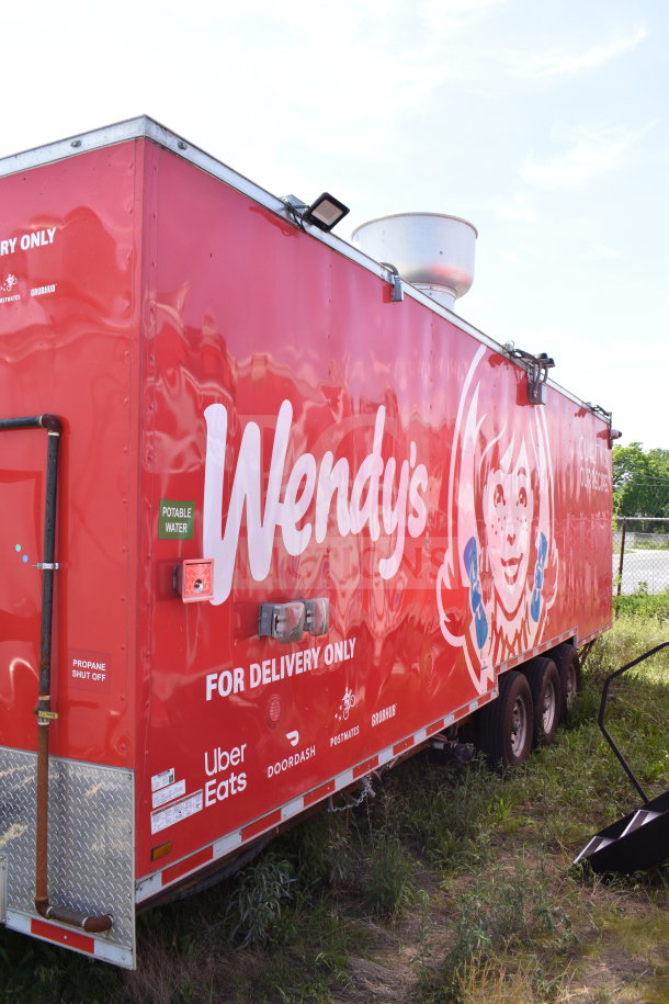 Red Wendy's food trailer with branding, dual axles, and a propane shut off. Labeled for delivery use only.