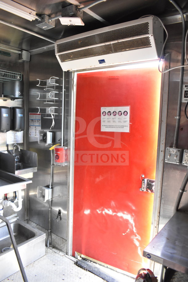Wendy's food trailer interior with stainless steel fixtures, sink, red door, and equipment setup. Features air curtain and dispensers.
