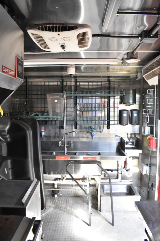 Wendy's food trailer interior showing stainless steel sinks, drying racks, and industrial ventilation. Clean and well-maintained.