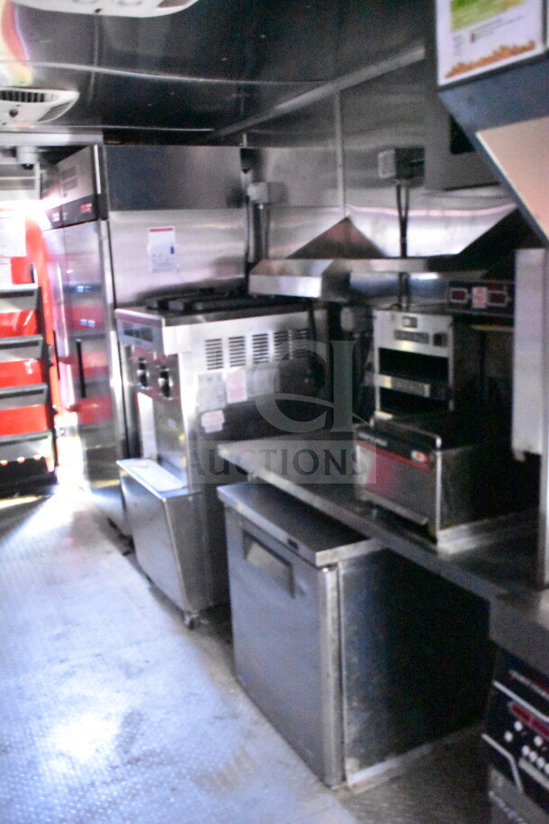 Wendy's food trailer interior with stainless steel kitchen equipment, including a grill, fryer, and refrigerated unit. Clean and well-maintained.