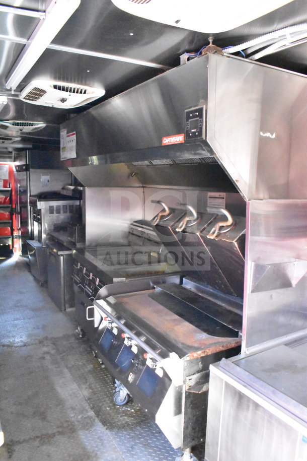 Wendy's food trailer interior with stainless steel kitchen equipment, including a CaptiveAire hood and grill. Industrial setting.