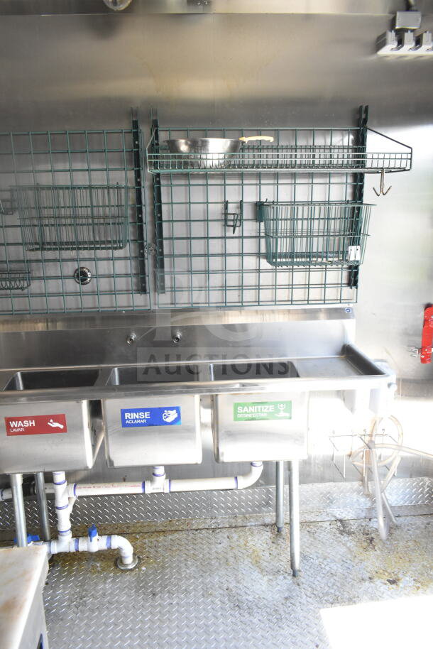 Diamond Cargo 8.5'x24' food trailer interior with wash, rinse, sanitize sinks and wire shelving. VIN: 53NBE2429M1089847.