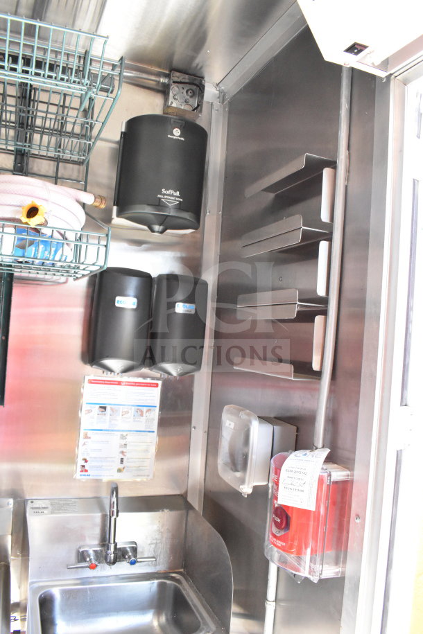 Interior of a 2022 Rock Solid Cargo food trailer showing a stainless steel sink, paper towel dispensers, and shelving.