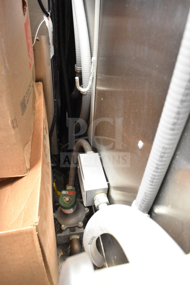 Inside view of 2022 Rock Solid Cargo food trailer, showing piping, electrical connections, and cardboard boxes.