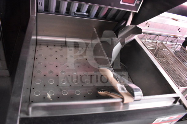 Interior of 2022 Rock Solid Cargo 8.5x28 Wendy's Food Trailer featuring a CaptiveAire Grease Hood and fry basket setup.