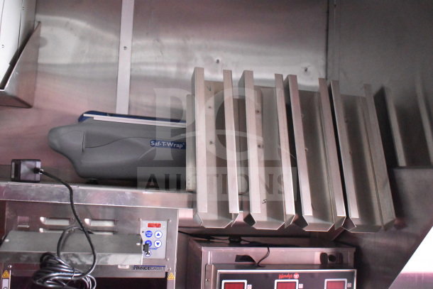 2022 Rock Solid Cargo food trailer interior, featuring a Saf-T-Wrap system, Prince Castle equipment, and stainless steel shelving.