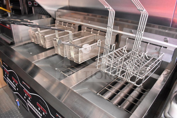 2022 Rock Solid Cargo 8.5x28 food trailer interior with Henny Penny fryer baskets and controls, featuring a CaptiveAire grease hood.