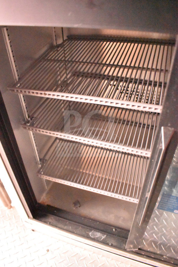 Interior of 2022 Rock Solid Cargo food trailer's refrigeration unit, showing multiple metal shelves in good condition.