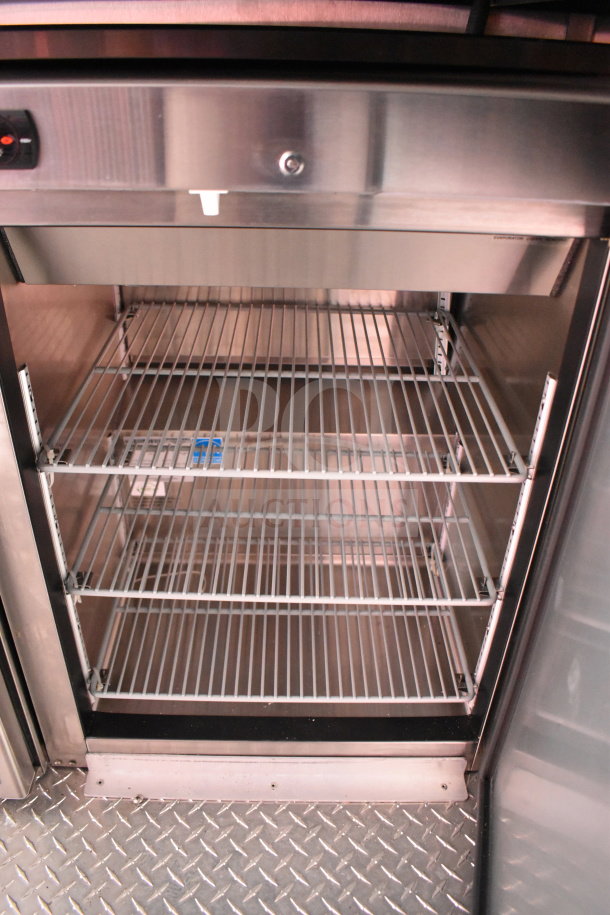2022 Rock Solid Cargo food trailer interior showing stainless steel refrigeration shelving and diamond plate flooring.
